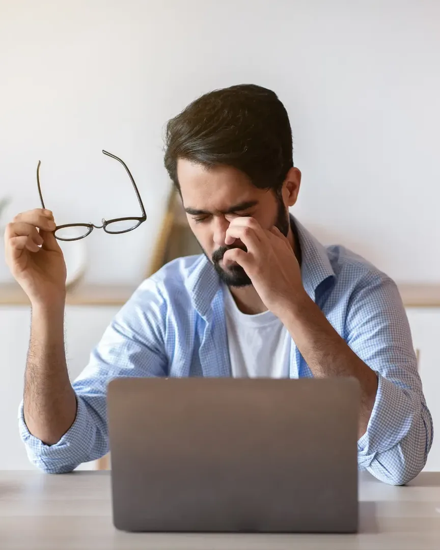 Erschöpfte Person am Laptop